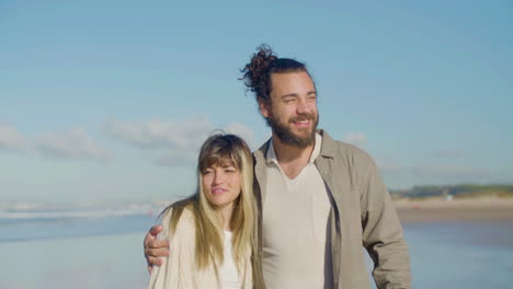 Happy-Caucasian-couple-strolling-along-seashore