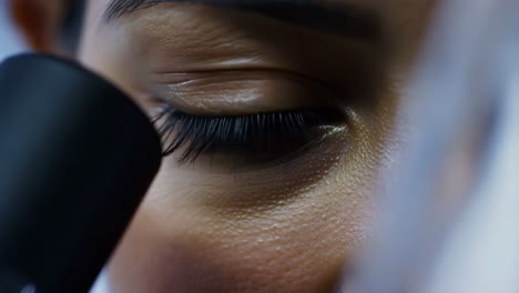 close-up of a person's eye looking through a microscope