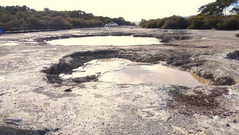 low drone flyover of bubbling volcanic lake mud pools