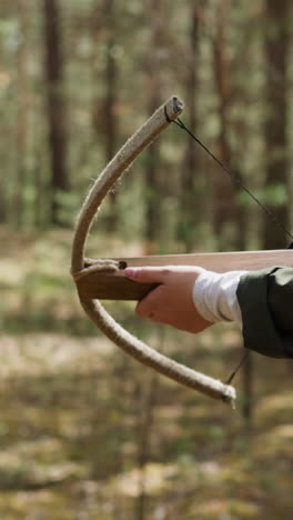 woman in long dress walks in forest with crossbow in hands, historical reconstruction, middle ages