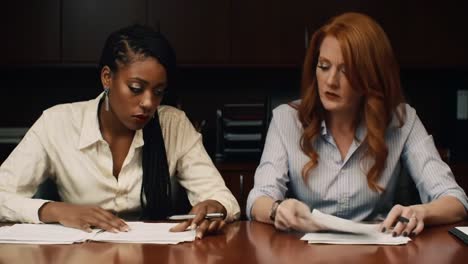 focused collaboration: two professionals engaged in detailed review of important documents in a corporate setting