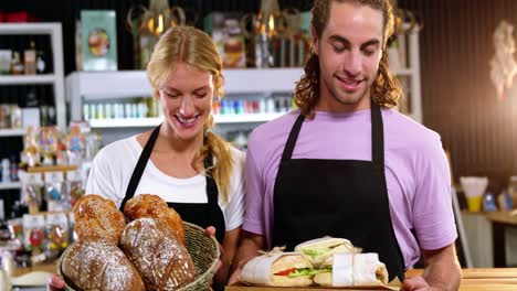 camarero y camarera sosteniendo pan y sándwiches