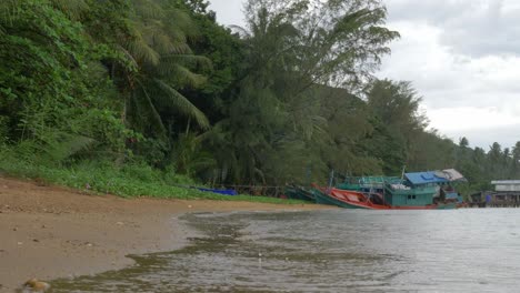 Eine-Niedrige-Zeitlupenaufnahme-Des-Strandes-An-Einem-Regnerischen-Tag-Mit-Einem-Versunkenen-Schiff-Im-Beschnittenen-Hintergrund