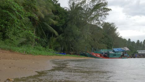 una toma en cámara lenta de la playa en un día lluvioso con un barco hundido en el fondo recortado