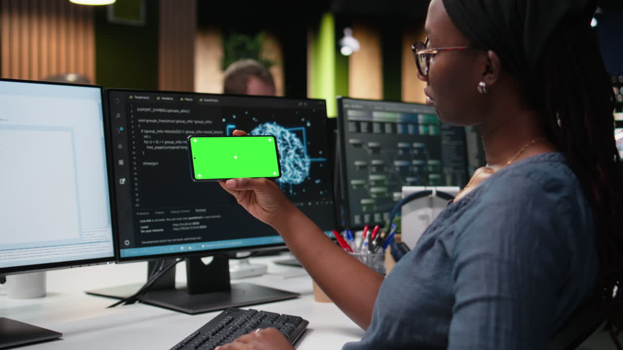 African American Woman Developer Holding Smartphone with Green Screen