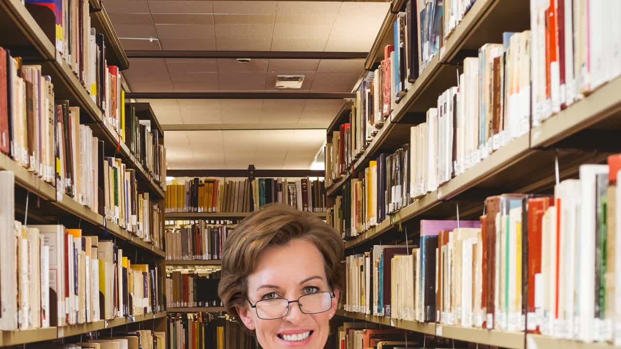 retrato de una maestra caucásica sonriendo en la biblioteca de la escuela