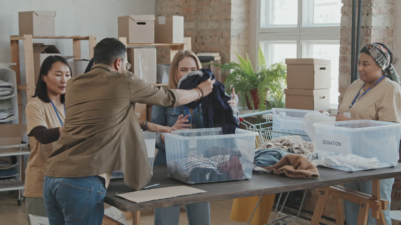 Cheerful Volunteer Team Sorting out Donated Clothes