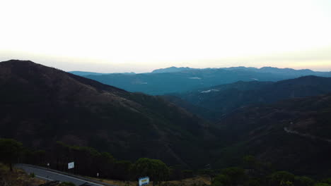 A-drone-rises,-revealing-the-skyline-of-the-Sierra-Bermeja-mountain-range
