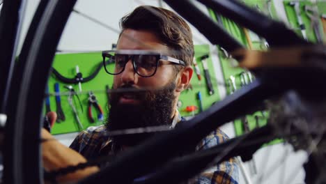 mechanic repairing bicycle in workshop