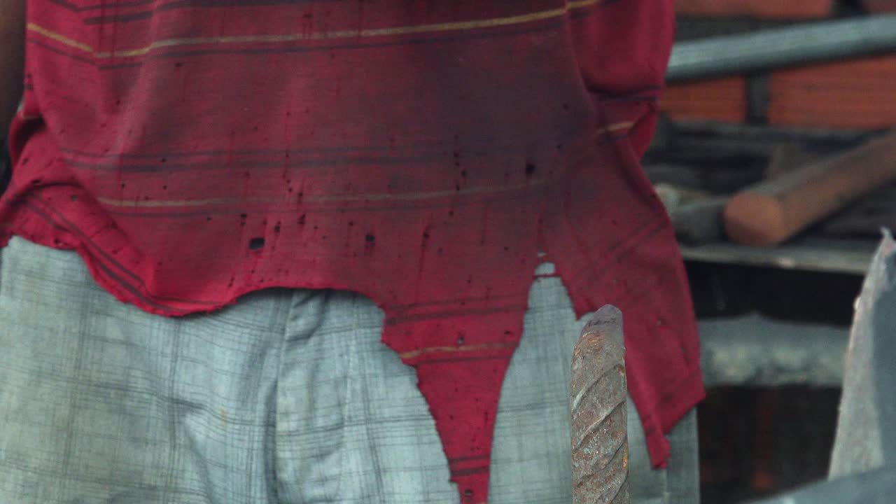 대장간에서 칼날 목을 망치질하는 금속 노동자