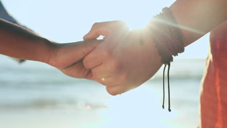 primer plano, pareja y tomados de la mano en la playa