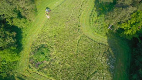 agricultural mower machine cuts grass of green field