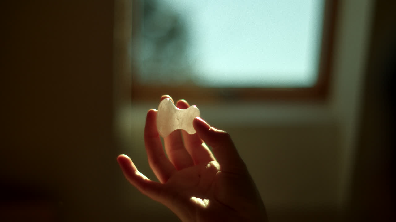 Hand Holding a White Crystal