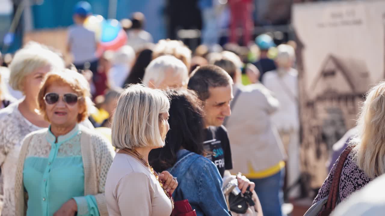 People during festival in city. People crowd walking on busy street on daytime
