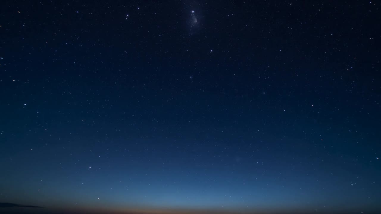 Vertikal video: Solnedgang falmer, bred himmel viser stjerner over kysten, orange horisontglød, tåge ses.