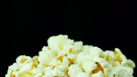 a bunch of popcorn on a black background slowly rotates 4k video