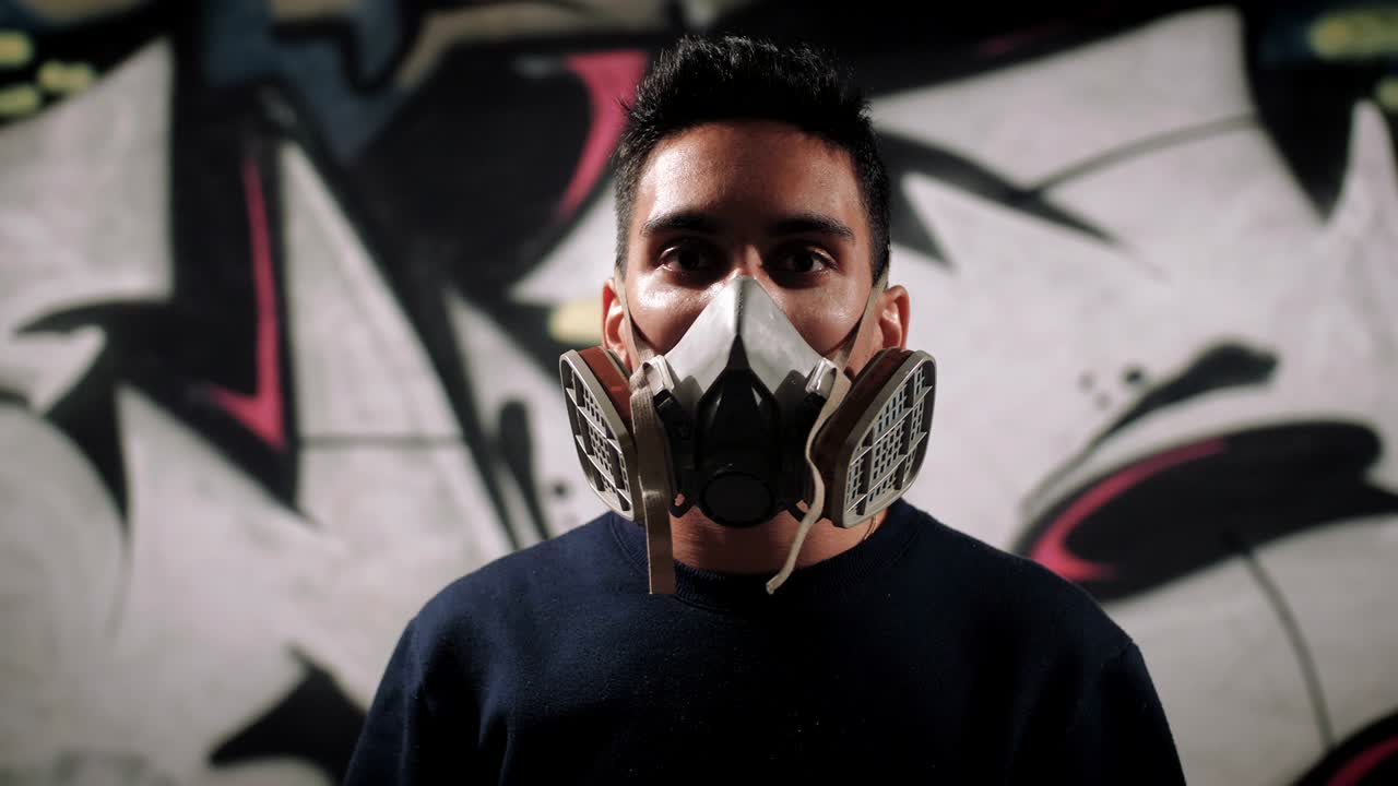 retrato de un artista de graffiti pintando en el metro sobre un fondo de graffitis, de cerca