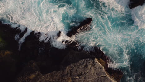 aerial view of ocean waves breaking on rocks beautiful blue sea splashing on shoreline coastal surf 4k