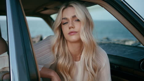 woman in a vintage car by the beach