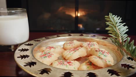 christmas cookies and milk for santa claus in front of a fireplace in 4k