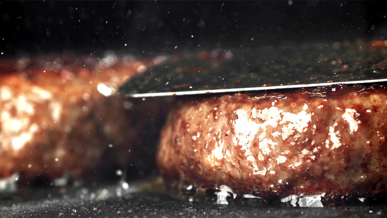 Close-up of Burger Patties Sizzling on a Hot Grill