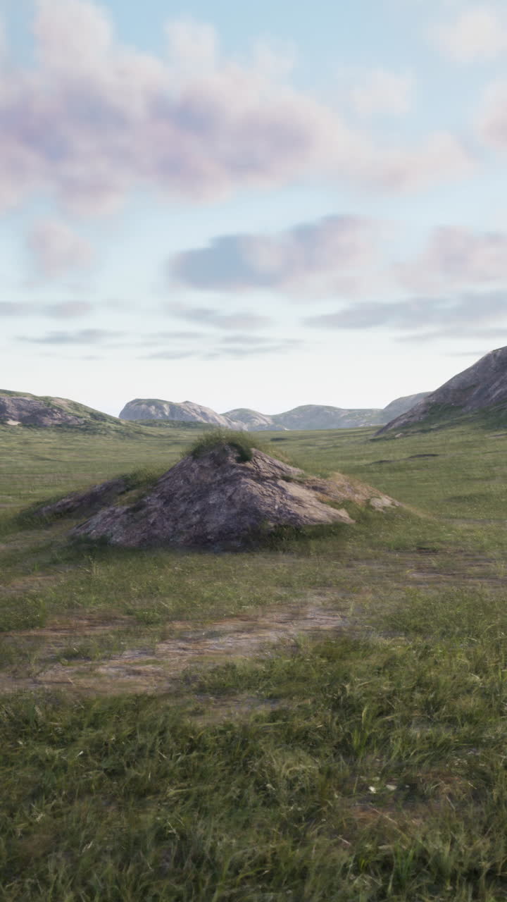 una vista panorámica de un campo de hierba con colinas y un cielo azul en el fondo