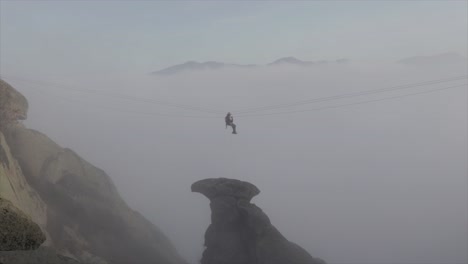 rock climber working on a zip line on a rescue mission on a foggy day