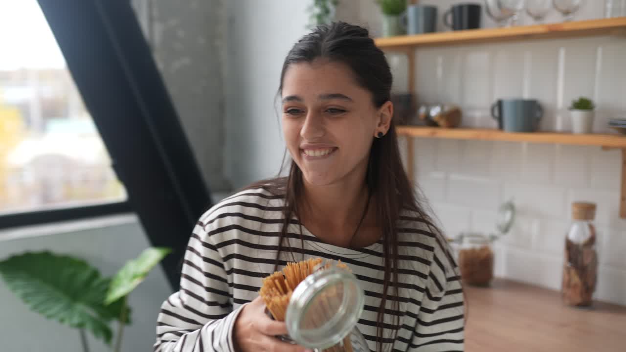 mujer mirando pasta en la cocina