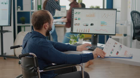 paralyzed man and teamworkers working in new normal office