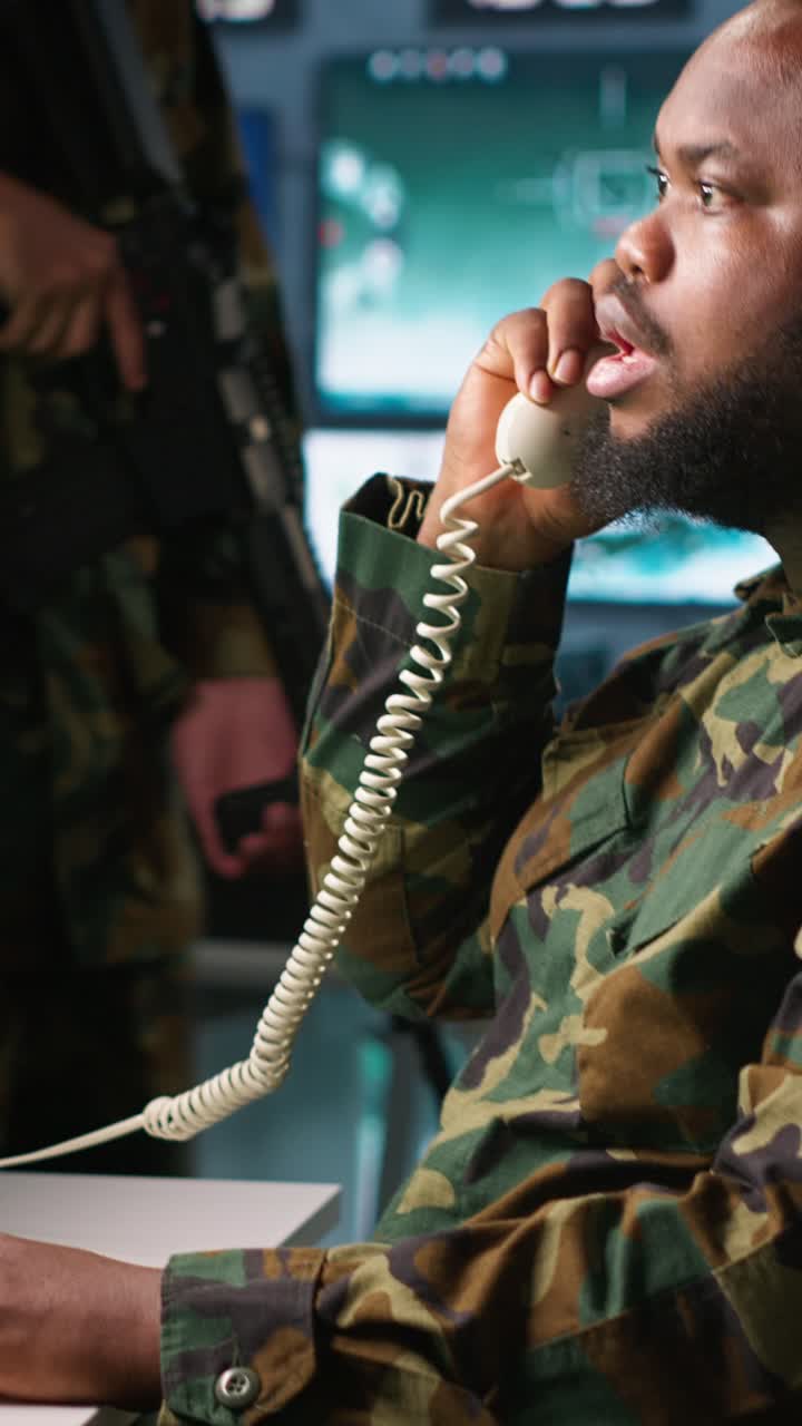 Video verticale Esperto militare in chiamata telefonica in una sala di monitoraggio