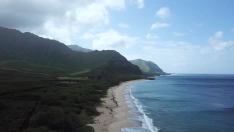 4k drone rising above makua beach hawaii revealing ocean and mountains