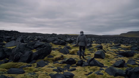 A person walking through a rocky landscape in Iceland