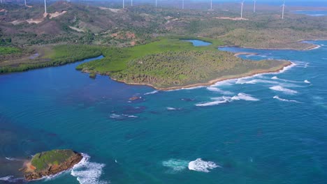 Vista-Aérea-De-La-Costa-Cerca-De-Maimon-Con-Turbinas-Eólicas-En-Segundo-Plano