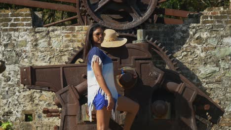 a female model at an ancient waterwheel used for a sugar cane plantation