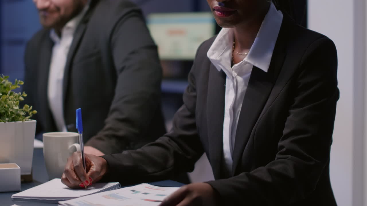 Close up of diverse colleagues working with tablet, laptop and blueprints to design building model