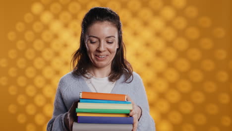 joyous person walking with pile of novels, feeling delighted, studio background