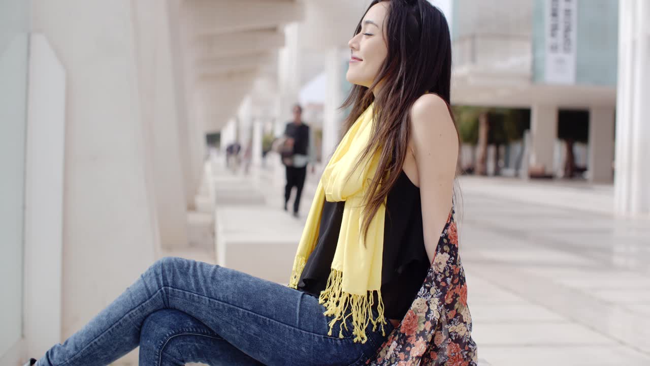 joven atractiva y elegante relajándose en la ciudad