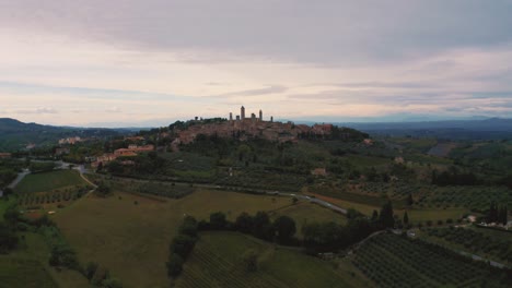 aerial drone footage of the medieval town san gimignano near siena, a masterpiece of historic architecture in the idyllic landscape of tuscany, italy with vineyards, hills and olive trees around