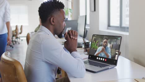 Hombre-Afroamericano-Usando-Una-Computadora-Portátil-Para-Videollamadas,-Con-Un-Colega-De-Negocios-En-La-Pantalla