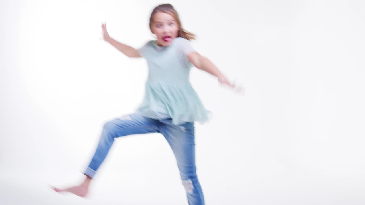 Ragazza giovane che corre e salta su sfondo bianco