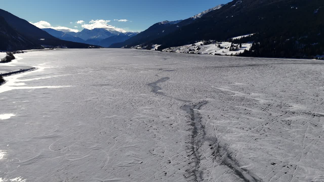 Frozen lake in The Alps during winter season (drone footage)