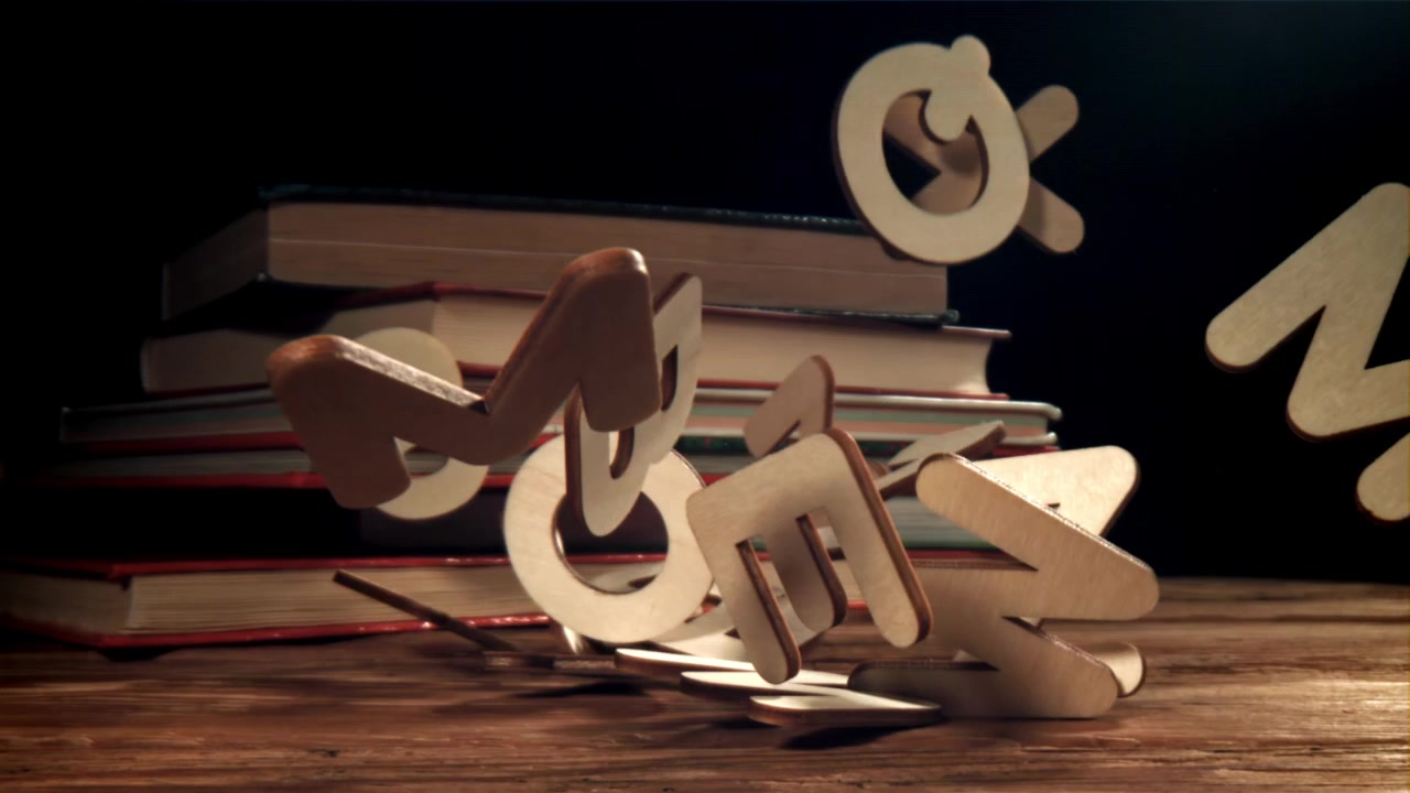 Lettere dell'alfabeto in legno che cadono su un tavolo con libri