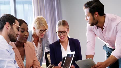 Businesspeople-interacting-over-a-laptop-and-digital-tablet