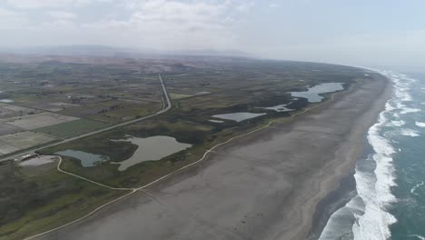 a breathtaking aerial view of wetlands meeting the ocean. a blend of sand, water, and greenery, ideal for travel blogs, conservation projects, and editorial use. mejia, arequipa, peru.