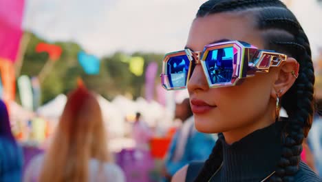 mujer en un festival de música con gafas de sol y trenzas de moda