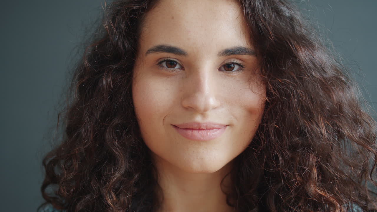 retrato de una mujer sonriente con el cabello rizado