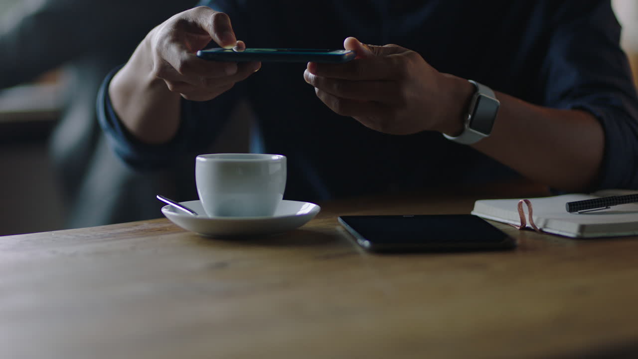 close up man hands using smartphone taking photo of coffee on mobile phone camera sharing lifestyle on social media enjoying relaxing in cafe