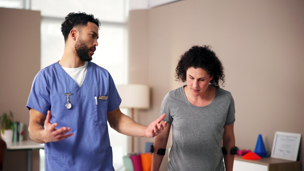 fisioterapeuta ayudando al paciente con muletas