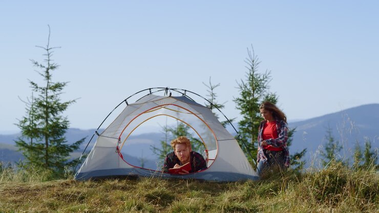 Man making notes in notebook in camping tent
