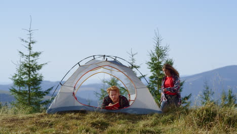 man making notes in notebook in camping tent